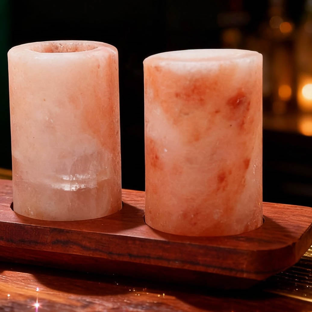 Ambachtelijke roze zoutglaasjes met houten tray, ideaal voor rituelen en drankjes.