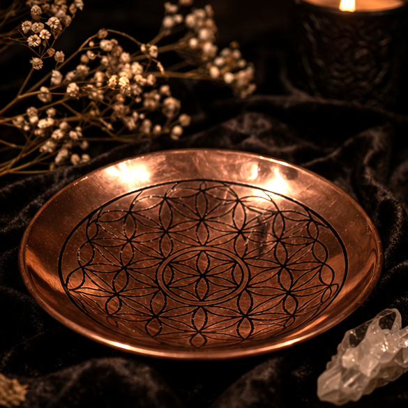 Spirituele koperen schaal met levensbloem patroon in donkere mystieke setting