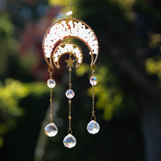 Maan Suncatcher met rozekwarts en K9-glas, hangend voor een zonnig raam, creëert regenbogen en een spirituele sfeer.