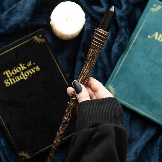 Zwarte obsidiaan toverstaf met kristalpunt – spiritueel ritueelinstrument voor bescherming en aarding.