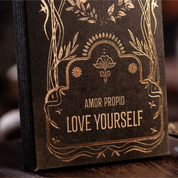 Een fraai vormgegeven doosje Sagrada Madre Ritual wierook met Love Yourself geur (oosterse bloemen), getoond op een rustieke houten achtergrond. Bevat 6 wierookstokjes met een brandtijd van 60 minuten elk, gemaakt van essentiële olie, houtskool, natuurlijk bindmiddel en zout. Perfect voor meditatie, zelfliefde en compassierituelen.