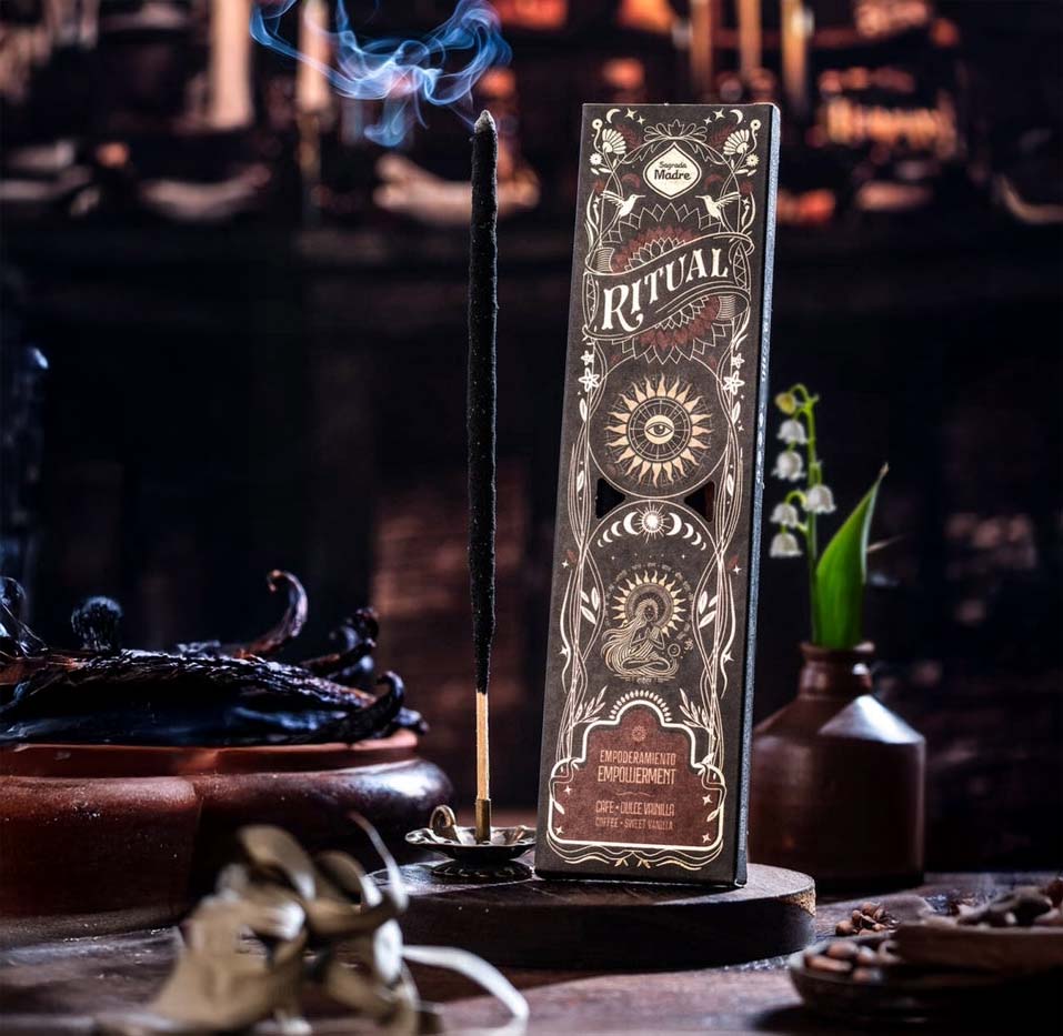 Een doosje Sagrada Madre Rituals wierook met Empowerment geur (koffie en vanille), getoond op een rustieke houten ondergrond. Bevat 6 wierookstokjes met een brandtijd van 60 minuten elk, gemaakt van geconcentreerde aromatische olie, houtskool, natuurlijk bindmiddel en zout. Ideaal voor meditatie, yoga en het versterken van innerlijke kracht.