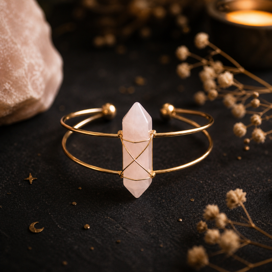 Rozenkwarts armband met roze edelsteen in gouden cuff op donkere mystieke achtergrond