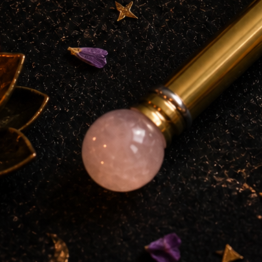 Close-up achterkant van rozenkwarts healing wand met goudkleurige metalen afwerking