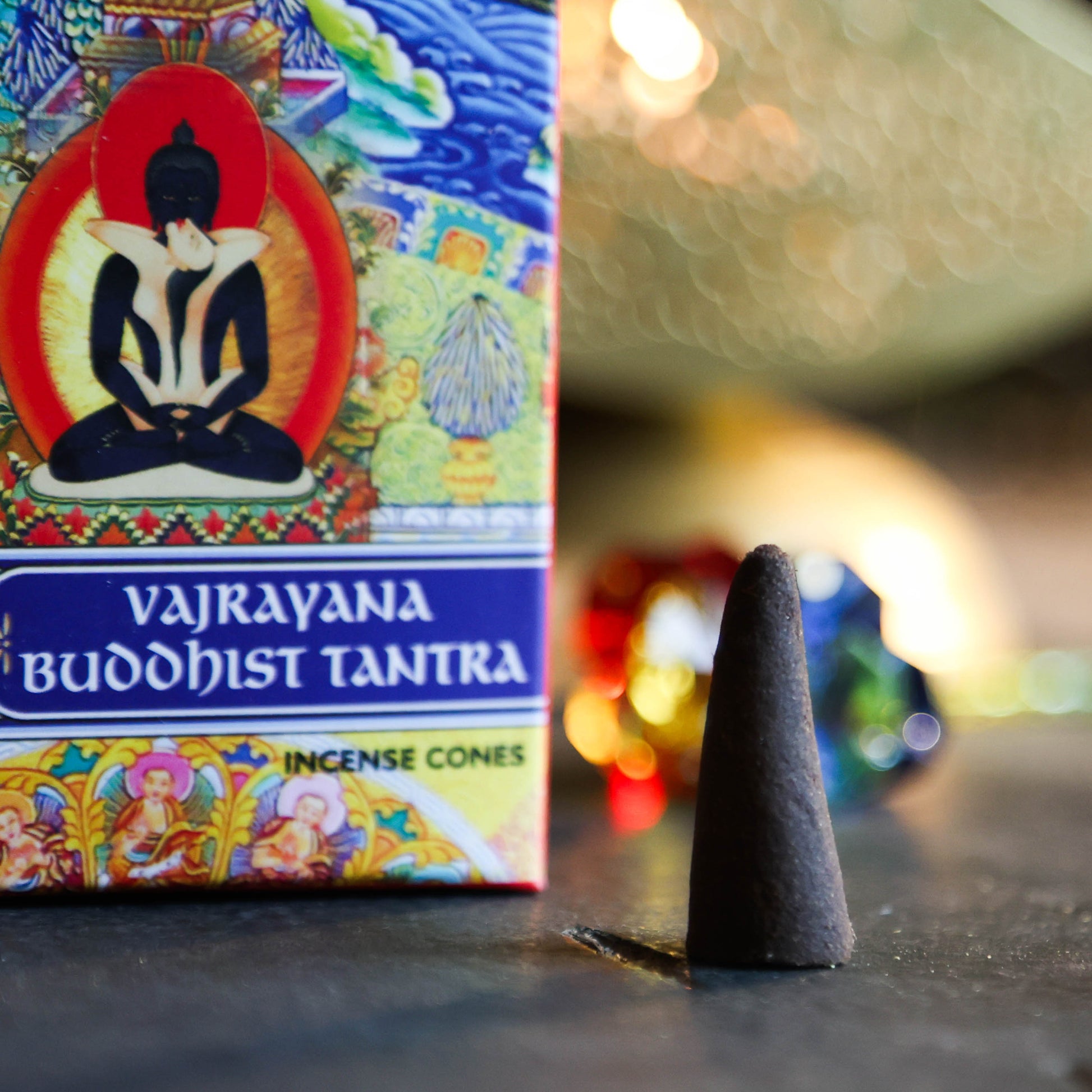 Close-up van één brandende Vajrayana Buddhist Tantra wierookkegel met zachte verlichting en aardse achtergrond.